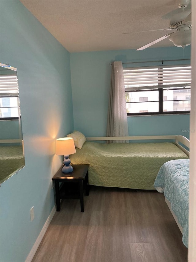 7951 58th Ave N Unit 308, Saint Petersburg, FL 33709 - bedroom with wood finished floors, a textured ceiling, baseboards, and a ceiling fan