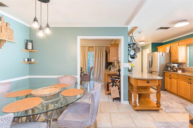 dining area with crown molding, visible vents, and light tile patterned floors