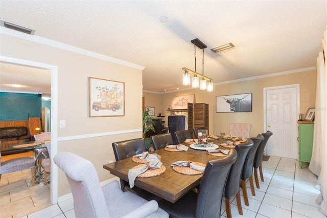 dining space featuring crown molding, light tile patterned flooring, and visible vents
