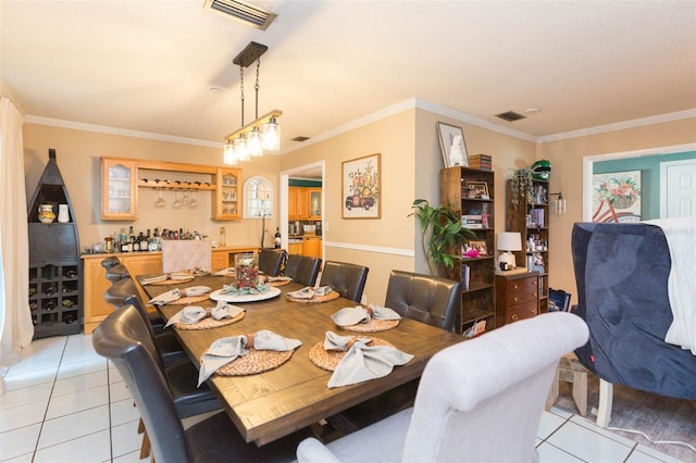dining space with visible vents, crown molding, and light tile patterned flooring