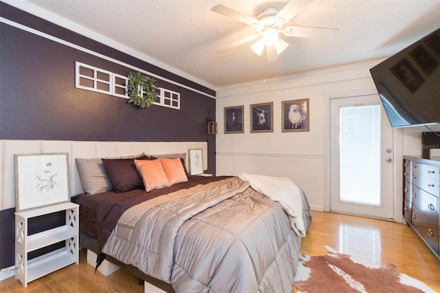 bedroom with a ceiling fan, ornamental molding, and wood finished floors