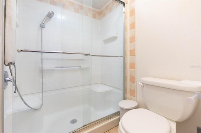 bathroom featuring a shower stall and toilet