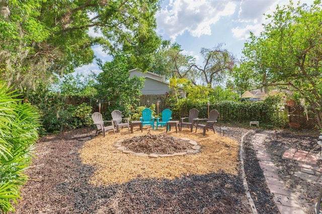 view of yard with an outdoor fire pit and fence