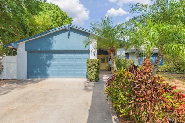 ranch-style house with a garage, stucco siding, and concrete driveway