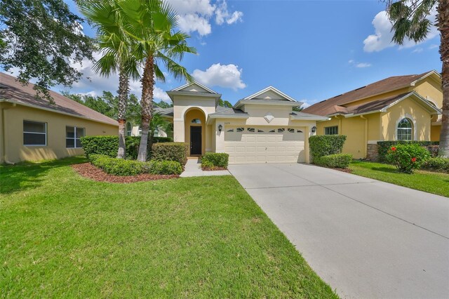 3315 Granite Ridge Loop, Land O Lakes, FL 34638 - view of front of home featuring a front lawn, concrete driveway, stucco siding, and a garage