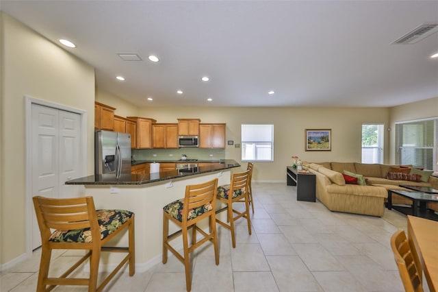 3315 Granite Ridge Loop, Land O Lakes, FL 34638 - kitchen featuring a wealth of natural light, stainless steel appliances, a breakfast bar area, and visible vents