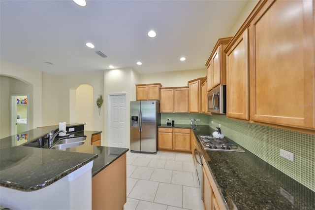 3315 Granite Ridge Loop, Land O Lakes, FL 34638 - kitchen featuring visible vents, a sink, arched walkways, backsplash, and appliances with stainless steel finishes