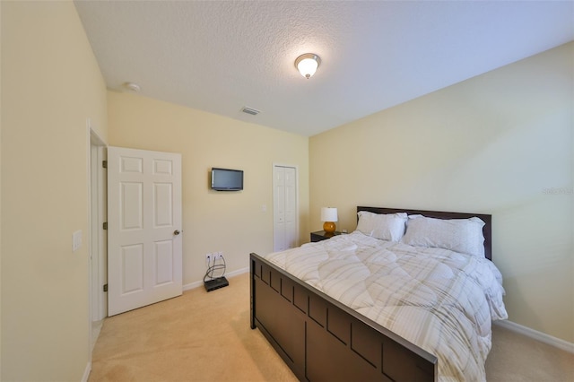 3315 Granite Ridge Loop, Land O Lakes, FL 34638 - bedroom with a closet, a textured ceiling, visible vents, light carpet, and baseboards