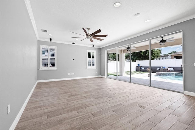 unfurnished living room featuring a healthy amount of sunlight, ceiling fan, ornamental molding, and light wood-type flooring