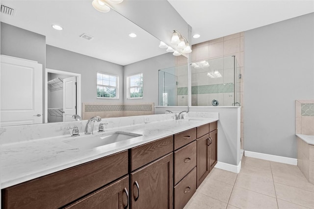 full bath featuring a sink, double vanity, tile patterned floors, visible vents, and a stall shower