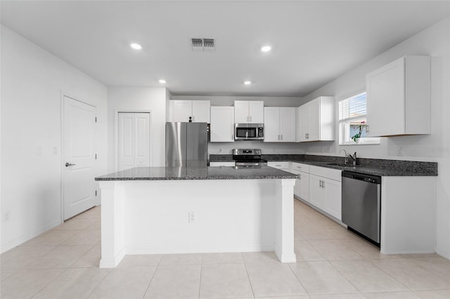 kitchen with recessed lighting, stainless steel appliances, dark stone countertops, visible vents, and white cabinets