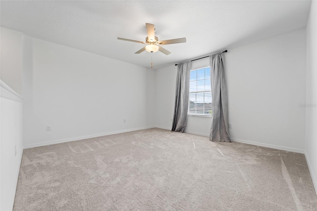 unfurnished room with a ceiling fan, carpet flooring, and baseboards