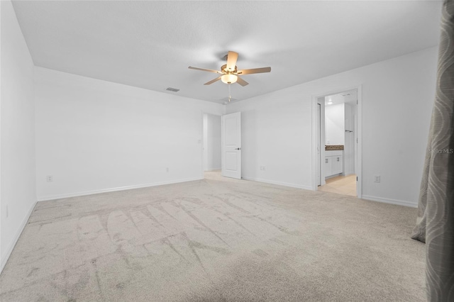 unfurnished bedroom with baseboards, visible vents, light carpet, and connected bathroom