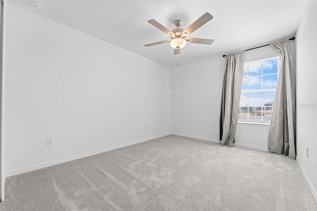 unfurnished room with baseboards, ceiling fan, and carpet