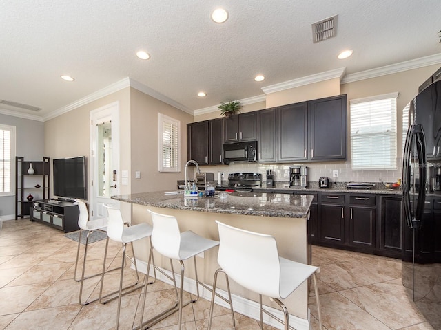 311 Vista Cruiser Ln, Oldsmar, FL 34677 - kitchen with black appliances, a sink, a kitchen island with sink, dark stone counters, and recessed lighting