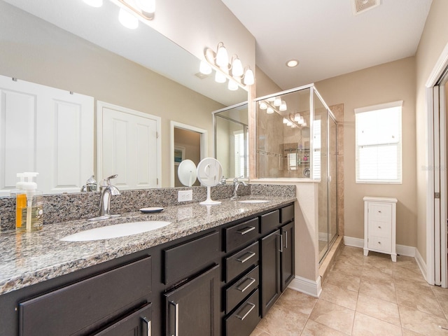 311 Vista Cruiser Ln, Oldsmar, FL 34677 - full bathroom featuring a shower stall, double vanity, tile patterned flooring, and baseboards