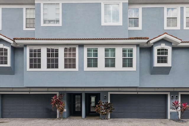 3111 W De Leon St Unit 8, Tampa, FL 33609 - view of property featuring a garage, stucco siding, and decorative driveway