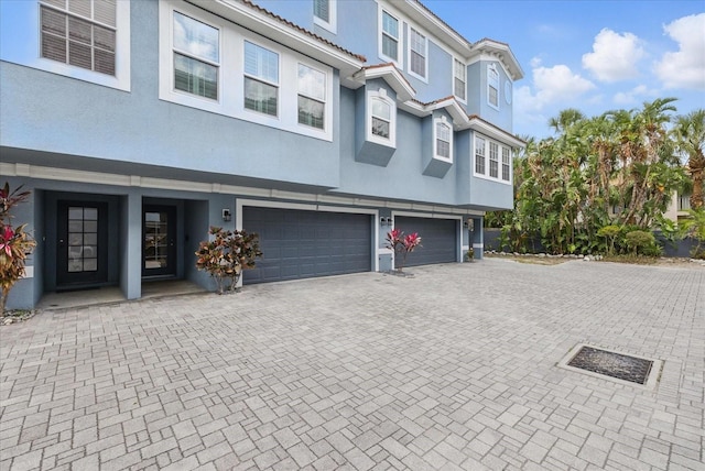 3111 W De Leon St Unit 8, Tampa, FL 33609 - view of front of property with stucco siding, a garage, and driveway