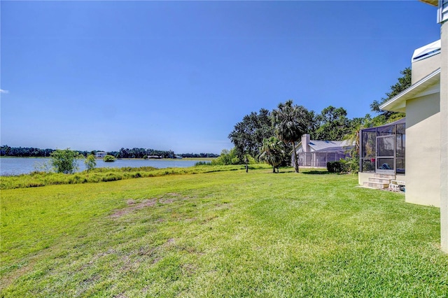 view of yard with a water view and a lanai
