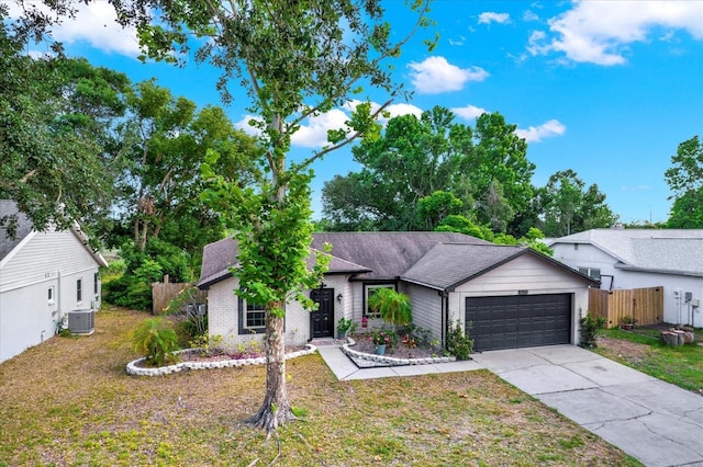 ranch-style home with fence, an attached garage, central AC, a front yard, and driveway