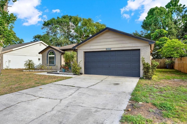 ranch-style house featuring fence, a front yard, driveway, and brick siding