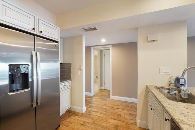 433 Mariner Dr Unit 433, Tarpon Springs, FL 34689 - kitchen with light stone countertops, stainless steel fridge, baseboards, light wood-type flooring, and visible vents