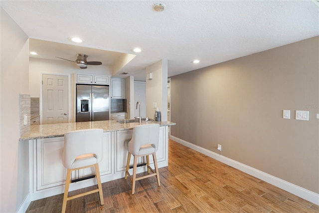 433 Mariner Dr Unit 433, Tarpon Springs, FL 34689 - kitchen with a peninsula, baseboards, stainless steel fridge, and a kitchen breakfast bar