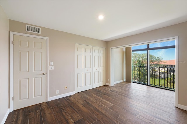 433 Mariner Dr Unit 433, Tarpon Springs, FL 34689 - unfurnished bedroom with baseboards, access to outside, dark wood-type flooring, and visible vents