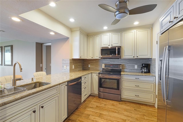 433 Mariner Dr Unit 433, Tarpon Springs, FL 34689 - kitchen featuring light stone countertops, appliances with stainless steel finishes, a sink, light wood finished floors, and a ceiling fan