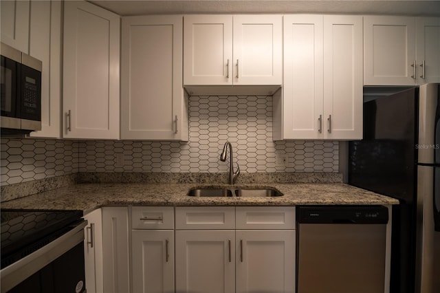 1716 11th Ave N, Saint Petersburg, FL 33713 - kitchen with light stone countertops, stainless steel dishwasher, white cabinets, backsplash, and a sink