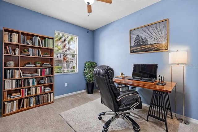 carpeted home office featuring baseboards and a ceiling fan