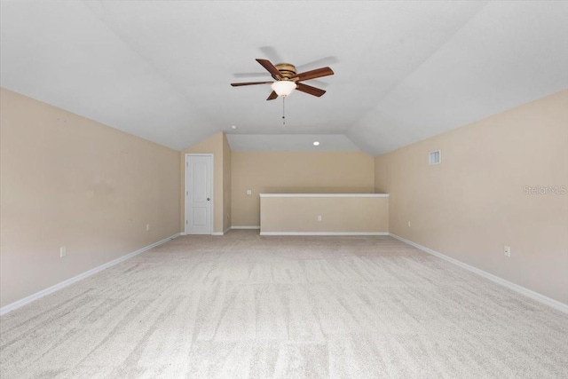 additional living space featuring visible vents, ceiling fan, light colored carpet, and vaulted ceiling