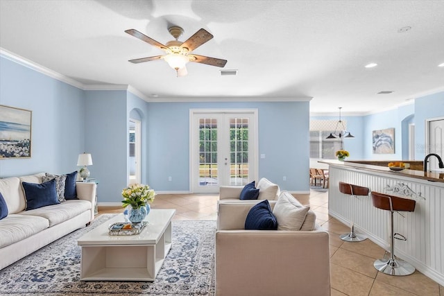 living room with crown molding, visible vents, and light tile patterned flooring