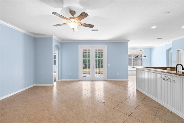 spare room featuring crown molding, visible vents, baseboards, and light tile patterned flooring
