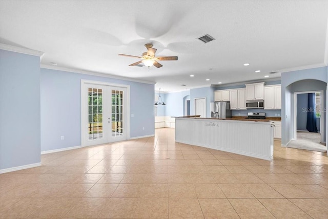 unfurnished living room featuring crown molding, visible vents, baseboards, and a ceiling fan