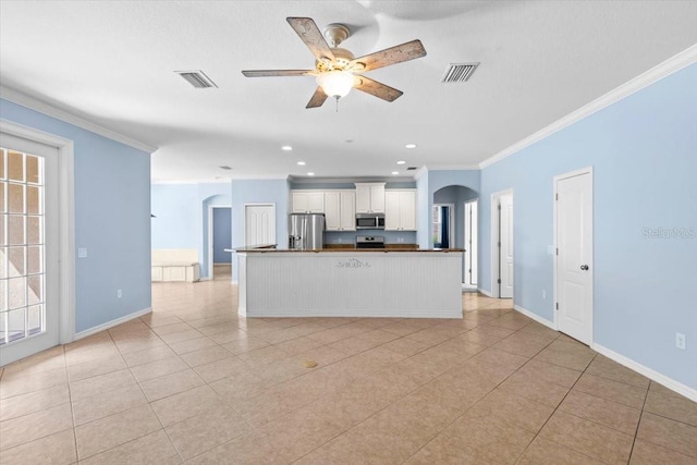 unfurnished living room with arched walkways, crown molding, visible vents, and a ceiling fan