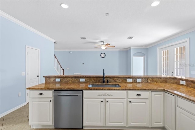 kitchen featuring a sink, stainless steel dishwasher, dark stone counters, and white cabinets