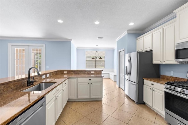 kitchen featuring crown molding, white cabinets, appliances with stainless steel finishes, and a sink