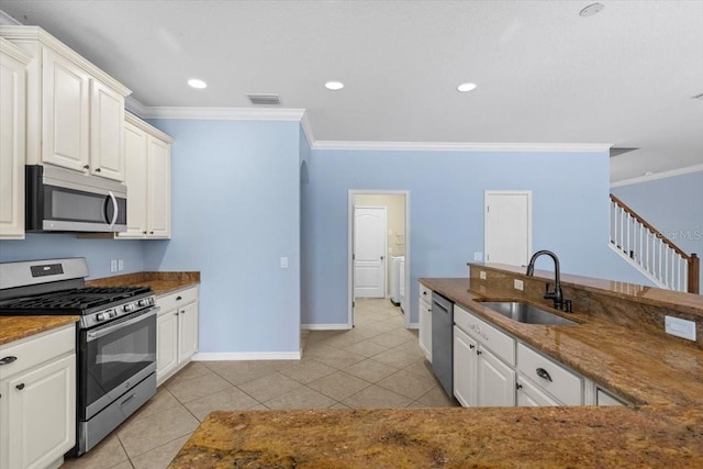 kitchen featuring a sink, crown molding, baseboards, and appliances with stainless steel finishes