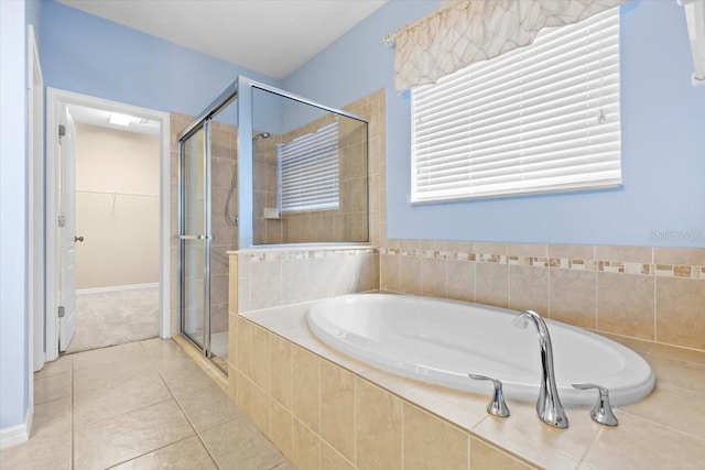 bathroom featuring tile patterned floors, a garden tub, a shower stall, and a walk in closet