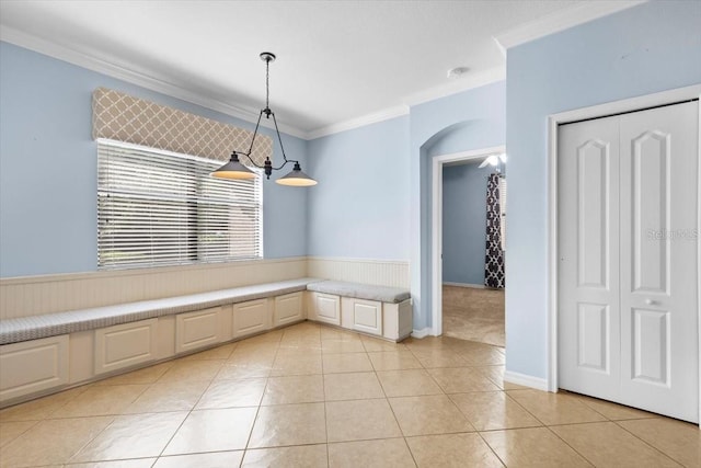 unfurnished dining area with crown molding and light tile patterned floors