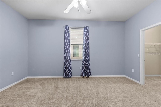 carpeted empty room with baseboards and ceiling fan