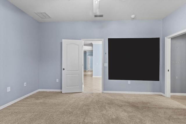 empty room featuring carpet, baseboards, and visible vents