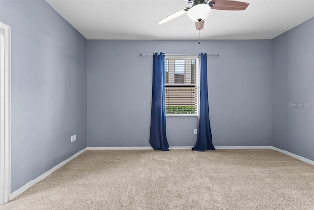 spare room with carpet flooring, baseboards, and a ceiling fan