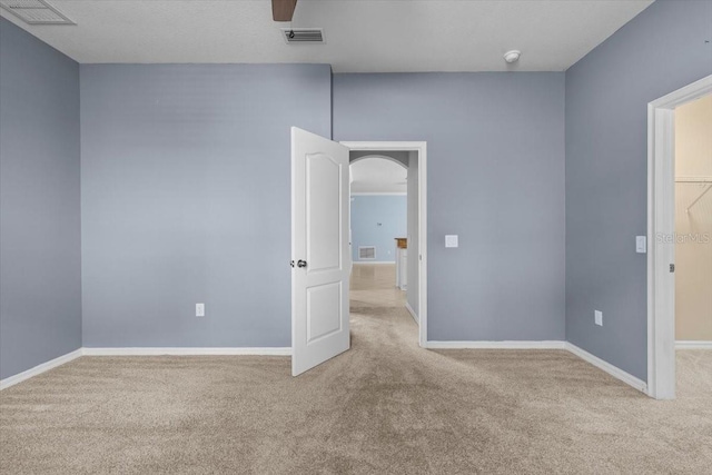 unfurnished room featuring baseboards, visible vents, and carpet