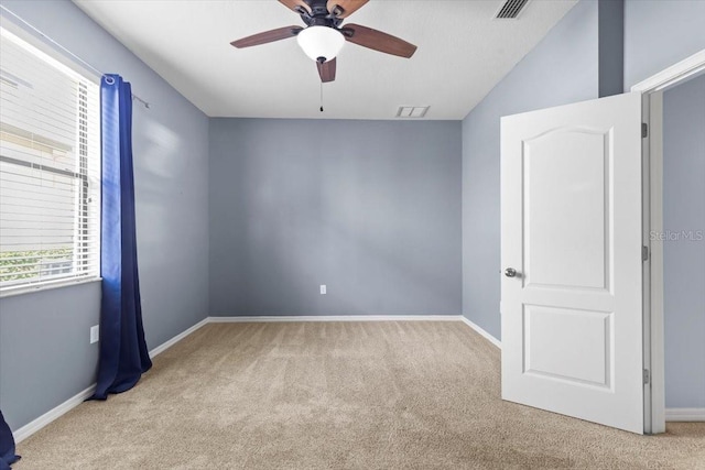 carpeted empty room featuring visible vents, baseboards, and ceiling fan