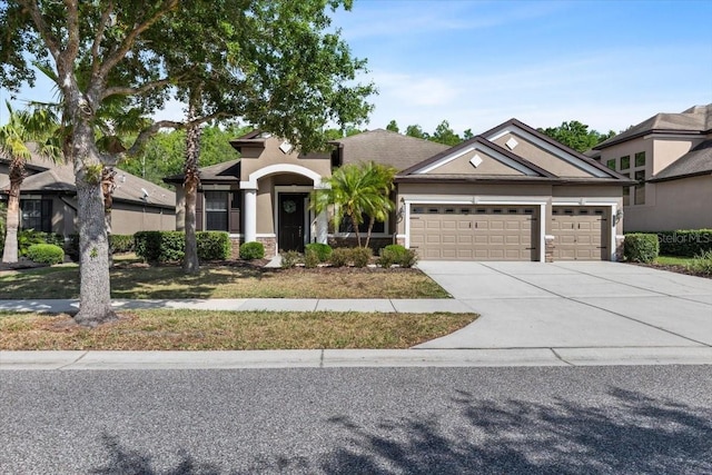 view of front facade featuring driveway, stucco siding, and a garage