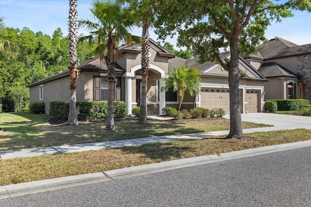 mediterranean / spanish-style home featuring concrete driveway, a garage, stucco siding, and a front lawn