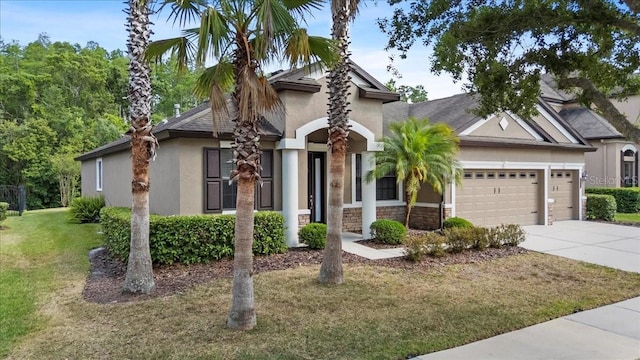 mediterranean / spanish house featuring a front yard, an attached garage, stucco siding, and driveway