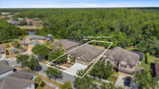 drone / aerial view with a wooded view and a residential view